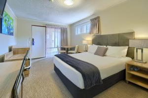 奥尔巴尼Albany Motel & Apartments的酒店客房设有一张大床和一张桌子。