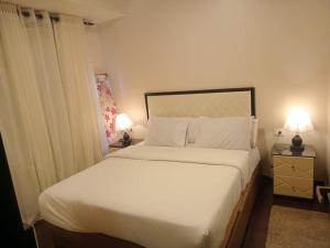 沙姆沙伊赫Apartment in Porto Sharm VIP的一间卧室配有一张带两盏灯的大型白色床。