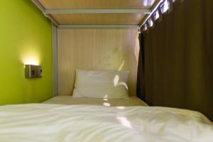 曼谷西亚梅子旅馆的绿色墙壁间的一张床位