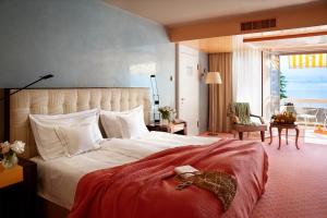 阿斯科纳Hotel Eden Roc - The Leading Hotels of the World的一间带大床的卧室和一个阳台