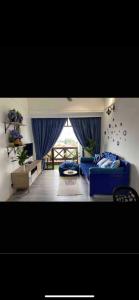 马六甲Century Mahkota Apartments的客厅设有蓝色的沙发和窗户。