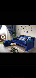 马六甲Century Mahkota Apartments的客厅配有蓝色的沙发和桌子