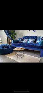 马六甲Century Mahkota Apartments的客厅配有一张蓝色的沙发,配有一张桌子