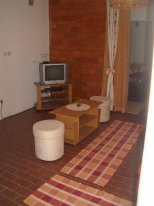 格鲁达Apartment Dario的客厅配有两把脚凳和电视