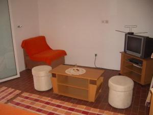 格鲁达Apartment Dario的客厅配有红色椅子和电视