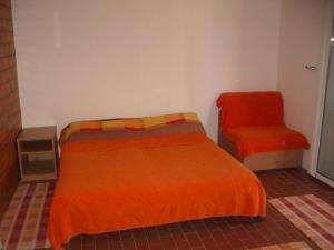 格鲁达Apartment Dario的一间卧室配有一张床和一把椅子
