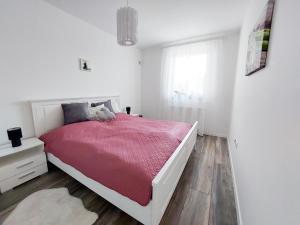 克塞洛Juhar Apartman的白色卧室配有一张带红色毯子的床