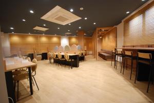 雾岛市Sun Hotel Kokubu Kagoshima的一间在房间内配有桌椅的餐厅