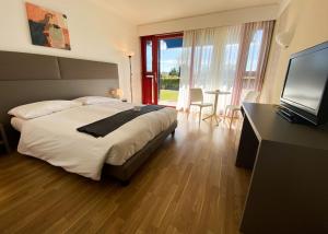 瑟皮亚诺赛皮阿诺酒店的一间卧室配有一张床、一台电视和一张桌子