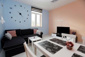 布尔加斯Lux Apartment " Central street "的客厅配有沙发和墙上的时钟