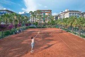 阿拉尼亚里维埃拉酒店加Spa的网球运动员在网球场上手持网球拍