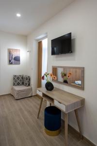 卡拉马塔Kalypso Apartments的客厅配有桌子,墙上配有电视
