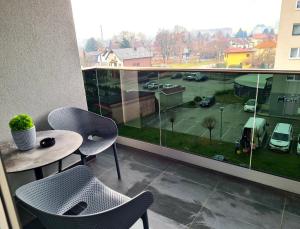 瓦拉日丁Wellness Apartments的阳台配有桌椅,享有停车场的景致。
