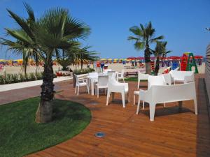 阿尔巴·阿德里亚蒂卡HOTEL BALTIC的一个带白色桌椅的庭院和海滩
