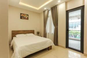 胡志明市ĐồiSao Homestay的一间卧室设有一张大床和一个窗户。