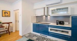 维也纳Best Western Plus Celebrity Suites的厨房配有蓝色橱柜和水槽