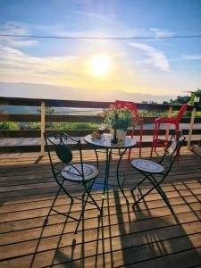 Ein KinyaSunset B&B的甲板上的一张桌子和两把椅子,享有日落美景