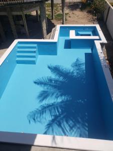 拉塞瓦Paradise Found的棕榈树旁边的蓝色游泳池