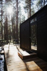 PunakiviÖÖD Hötels Laheranna SÄRA -with sauna的树林中带木甲板的房子