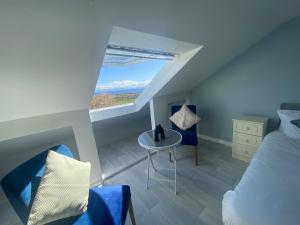 巴纳SeaClusion Barna的一间卧室配有一张床、一张桌子和一个窗户。