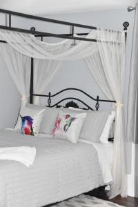 皮克图Seabank House Bed and Breakfast Hummingbird的白色的床、白色窗帘和枕头