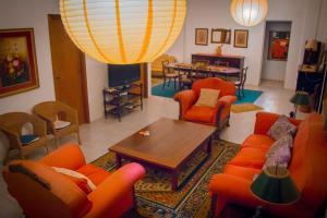 乌鲁瓜亚纳Hotel Solar dos Tchuccos的客厅配有橙色椅子和桌子