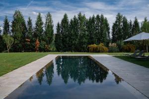 雷杰洛VIESCA Suites & Villas Il Borro Toscana的一个带遮阳伞的庭院内的游泳池