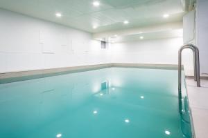 博尔库姆Hotel Haus am Park的室内的蓝色海水游泳池