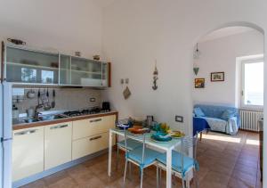 圣托斯特凡诺港Casa Alessia的一间带桌椅的厨房和一间带沙发的厨房
