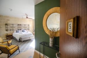森格莱阿Senglea Suites的客房设有带一张床和镜子的卧室
