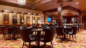 戴德伍德Celebrity Hotel的餐厅内带黑色椅子和桌子的酒吧