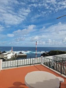 圣克鲁什达什弗洛里什"Apartamentos do Farol" com vista para o mar的阳台配有桌子,享有海景。
