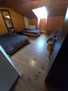 塞讷La chaumiere的一间卧室设有两张床,铺有木地板