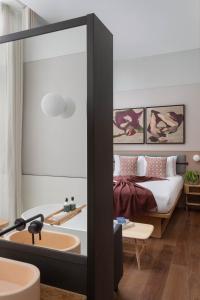 伦敦Inhabit Queen's Gardens, a Member of Design Hotels的卧室配有床和浴缸