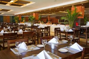 萨尔瓦多Gran Hotel Stella Maris Urban Resort & Conventions的餐厅设有木桌和白色餐巾