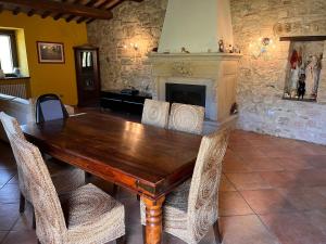 FermignanoAgriturismo Ca'Verdeselle的带壁炉的客房内的一张木桌和椅子