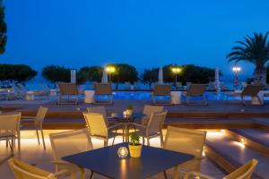埃雷特里亚埃雷特里亚内格罗蓬特度假酒店的庭院在晚上配有桌椅
