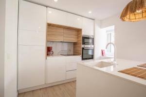 卡帕里卡海岸Sea, Surf & The City-RENOVATED APRIL 2022的白色的厨房配有白色橱柜和水槽