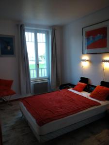 Moux-en-MorvanMaison Haute的一间卧室配有一张带红色床单的床和一扇窗户。