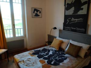 Moux-en-MorvanMaison Haute的一间卧室配有一张带蓝白色毯子的床
