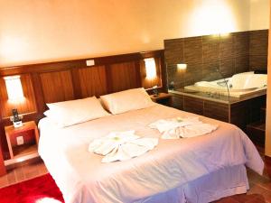 蒙特韦尔迪Hospedagem Spa da Alma的卧室配有带毛巾的大型白色床