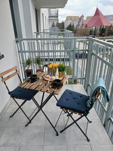 拉多姆Apartament z Sauna i Jacuzzi的阳台上的木桌和椅子