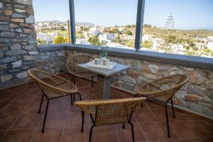 阿佐里姆诺斯Aegean Suite的露台上的桌椅,设有窗户
