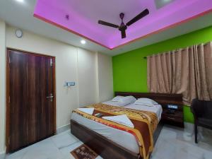 迪卡ICONIC Hotel Digha的一间卧室配有一张紫色天花板的床