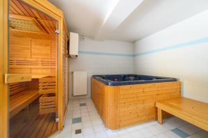 哈拉霍夫Penzion Petra, Harrachov的一间客房内的带木浴缸的桑拿浴室