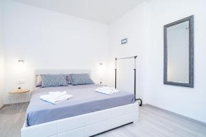 杜布罗夫尼克Apartment Olive的白色卧室配有一张带镜子的大床