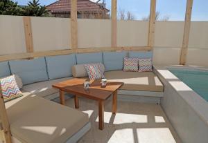锡蒂亚Bella Mare Sitia的一个带沙发和桌子的庭院和一个游泳池