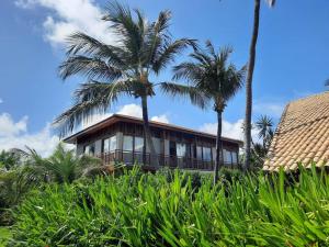普拉亚多Beach Premium Praia do Forte的前面有棕榈树的房子