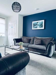 达尔基斯Dalkeith Five Bedroom House的客厅设有两张沙发和一堵蓝色的墙壁
