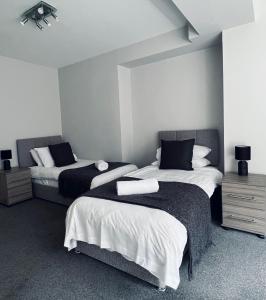 达尔基斯Dalkeith Five Bedroom House的一间卧室配有两张白色和黑色的床